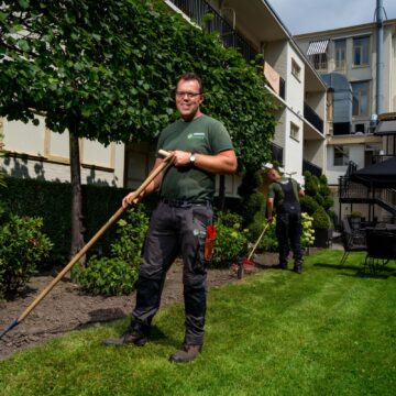 Twee hoveniers aan het werk bij een hotel.