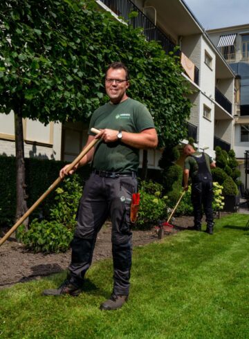 Twee hoveniers aan het werk bij een hotel.