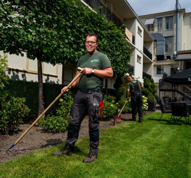 Twee hoveniers aan het werk bij een hotel.