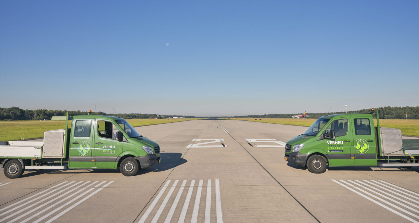 Twee Verheij busjes op een landingsbaan.